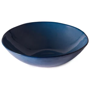 Perfect Hideaways: A large deep blue ceramic serving bowl with smooth curves and a glossy surface that reflects light. Perfect Hideaways shop