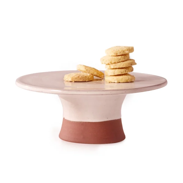 Perfect Hideaways: A handcrafted country cake stand with a wide, flat blush-toned surface and natural terracotta base, beautifully displaying a stack of buttery shortbread biscuits. Perfect Hideaways shop