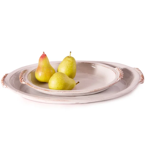 Perfect Hideaways: A pair of rustic white Classic Baking Dishes, one nested inside the other, with three ripe pears arranged inside the smaller dish. The shop