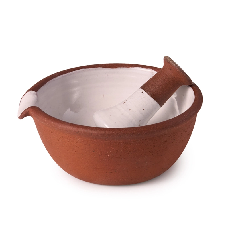Perfect Hideaways: A ceramic mortar and pestle set with a terracotta exterior and white glazed interior, ideal for grinding herbs or spices. The shop