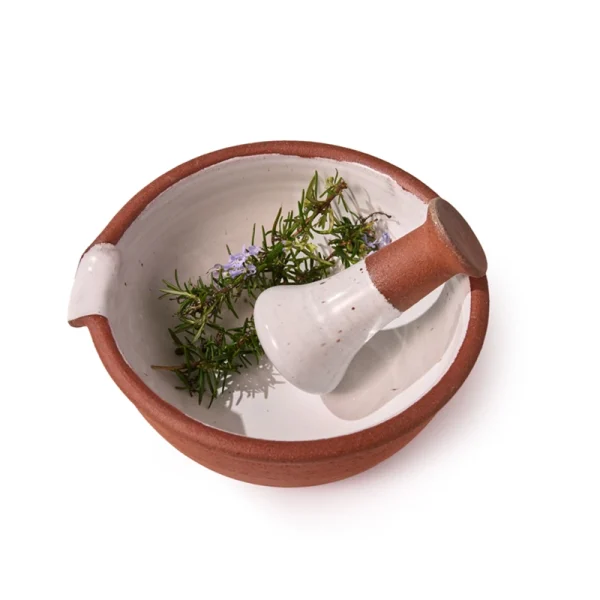 Perfect Hideaways: Overhead view of a ceramic mortar and pestle with fresh rosemary sprigs inside, showcasing its functional and rustic design. The shop