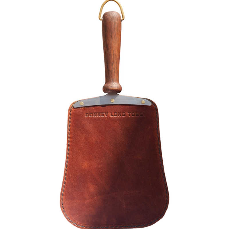 Perfect Hideaways: Donkey Fire Paddle. A handcrafted leather and wood fireside blower paddle with brass accents, embossed with "Donkey Long Tong" across the suede panel. Perfect Hideaways shop