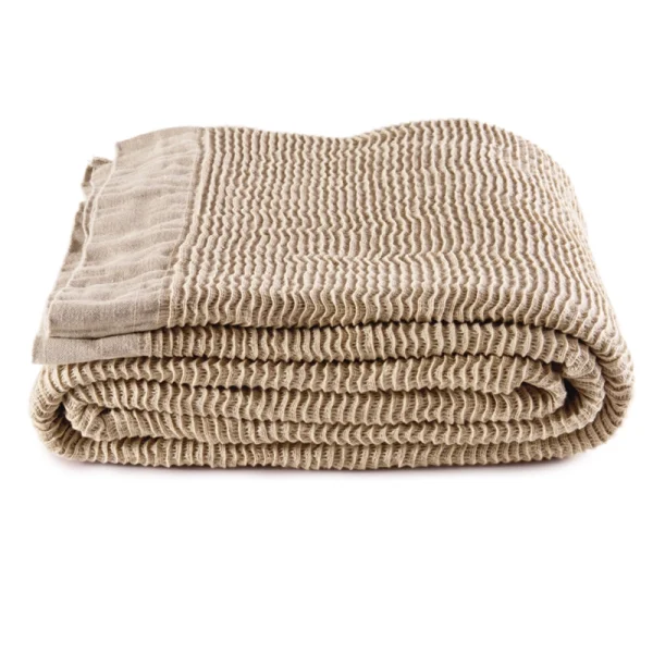 Perfect Hideaways: A neatly folded sand-toned linen blanket with a wavy textured weave and smooth border detailing, presented against a white background. Perfect Hideaways shop