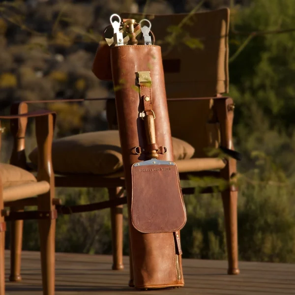Perfect Hideaways: Full Jack Sack. A rugged and luxurious leather tool case propped against a canvas safari chair, with stainless steel and wooden tools peeking out, perfectly suited to outdoor living. Perfect Hideaways shop