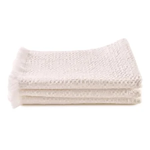 Perfect Hideaways: A stack of three white waffle-textured bathmats with fringed ends, neatly folded and displayed against a white background. Perfect Hideaways shop
