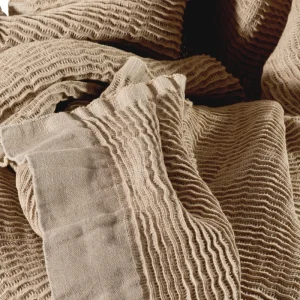 Perfect Hideaways: Close-up view of the blanket’s intricate crinkled weave and soft linen texture, highlighting the artisanal craftsmanship in neutral tones. Perfect Hideaways shop