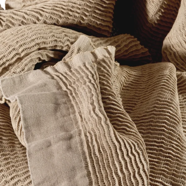 Perfect Hideaways: Close-up view of the blanket’s intricate crinkled weave and soft linen texture, highlighting the artisanal craftsmanship in neutral tones. Perfect Hideaways shop