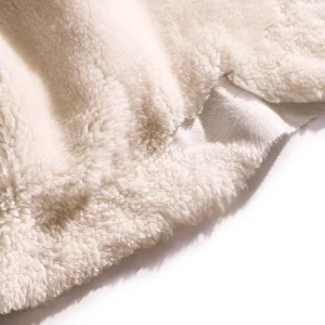 Perfect Hideaways: Detail view of the plush, cream-coloured wool fibres on a sheepskin rug, showing the natural hide underneath. Perfect Hideaways shop
