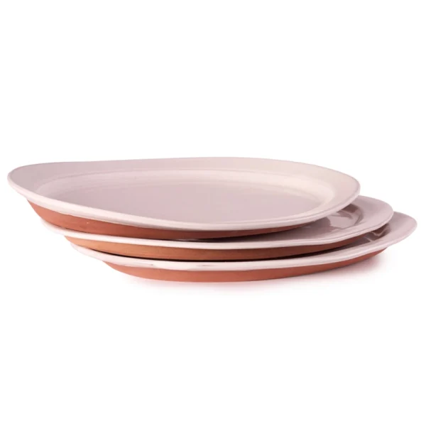Perfect Hideaways: Stack of three white-glazed country oval platters with terracotta undersides, showcasing artisanal craftsmanship and natural variation. Perfect Hideaways shop