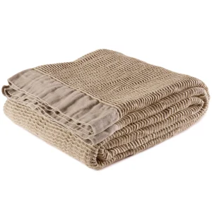 Perfect Hideaways: A beige linen blanket folded with visible stitched edging and crinkled texture, radiating understated luxury and comfort. Perfect Hideaways shop