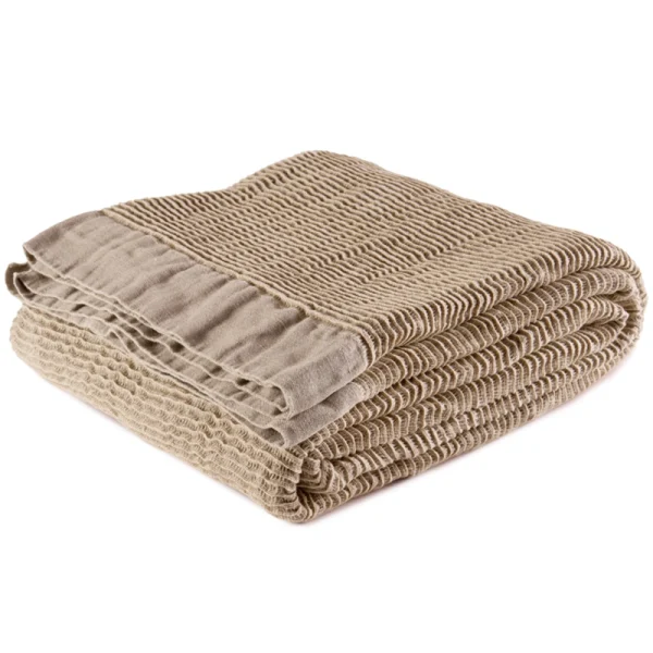Perfect Hideaways: A beige linen blanket folded with visible stitched edging and crinkled texture, radiating understated luxury and comfort. Perfect Hideaways shop