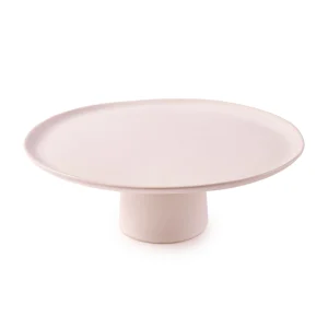 Perfect Hideaways: A minimalist ceramic cake stand with a wide, flat surface and short cylindrical base in a soft neutral glaze. The shop