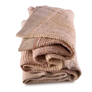 Perfect Hideaways: A neatly folded, Dune Bogolan Lounge Throw showcasing its rich layers of peach, terracotta, and beige hues in a tactile, grid-like texture. Perfect Hideaways shop
