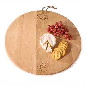 Perfect Hideaways: A styled Oak Cheese Platter topped with a wheel of camembert, red grapes, and a row of crackers, ready for serving. Perfect Hideaways shop