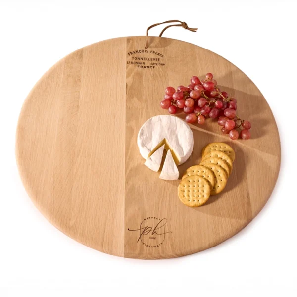 Perfect Hideaways: A styled Oak Cheese Platter topped with a wheel of camembert, red grapes, and a row of crackers, ready for serving. Perfect Hideaways shop