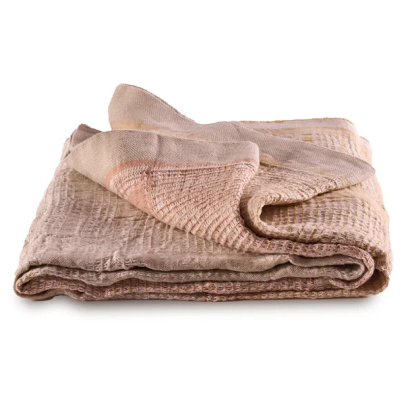 Perfect Hideaways: A flat-folded Dune Bogolan Lounge Throw in a palette of soft sand and terracotta, highlighting its subtly striped and waffle-textured weave. Perfect Hideaways shop