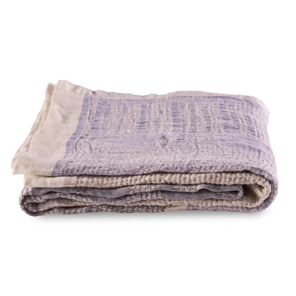 Perfect Hideaways: A single folded Ocean Bogolan Lounge Throw with a subtle lavender and beige pattern, revealing a finely woven texture and soft fabric finish. Perfect Hideaways shop