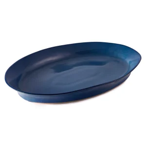 Perfect Hideaways: A single deep blue oval ceramic platter with a glossy glaze, highlighting its rich hue and refined silhouette. The shop