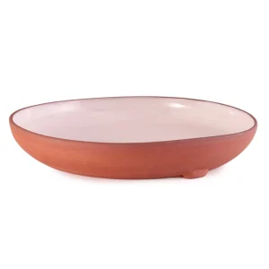 Perfect Hideaways: A shallow ceramic Wide Country Lebrillo bowl with a blush-glazed interior and natural terracotta exterior, elevated slightly on a subtle footed base for artisanal appeal, Perfect Hideaways sho