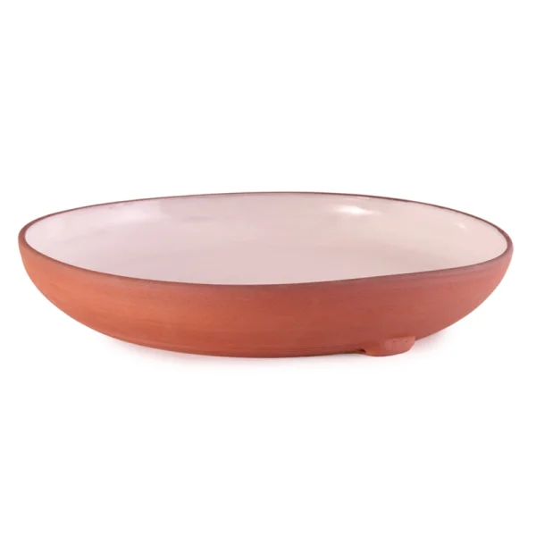 Perfect Hideaways: A shallow ceramic Wide Country Lebrillo bowl with a blush-glazed interior and natural terracotta exterior, elevated slightly on a subtle footed base for artisanal appeal, Perfect Hideaways sho
