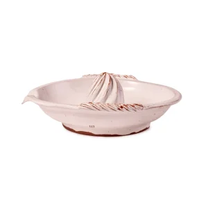 Perfect Hideaways: Side view of a white ceramic citrus juicer with textured rope-like handles and a terracotta base edge. Perfect Hideaways shop