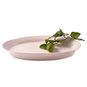 Perfect Hideaways: A soft white oval ceramic platter styled with a fresh green lime branch, blending natural beauty with handcrafted charm. The shop