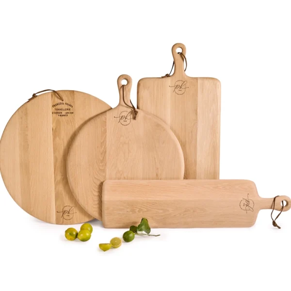 Perfect Hideaways: A collection of Oak Cheese Platters in various shapes and sizes, elegantly arranged with limes and a leather hanging loop detail. Perfect Hideaways shop