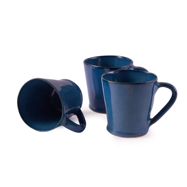 Perfect Hideaways: A set of three matching ceramic flare mug in a deep blue glaze, with two upright and one lying on its side to display the interior. The shop