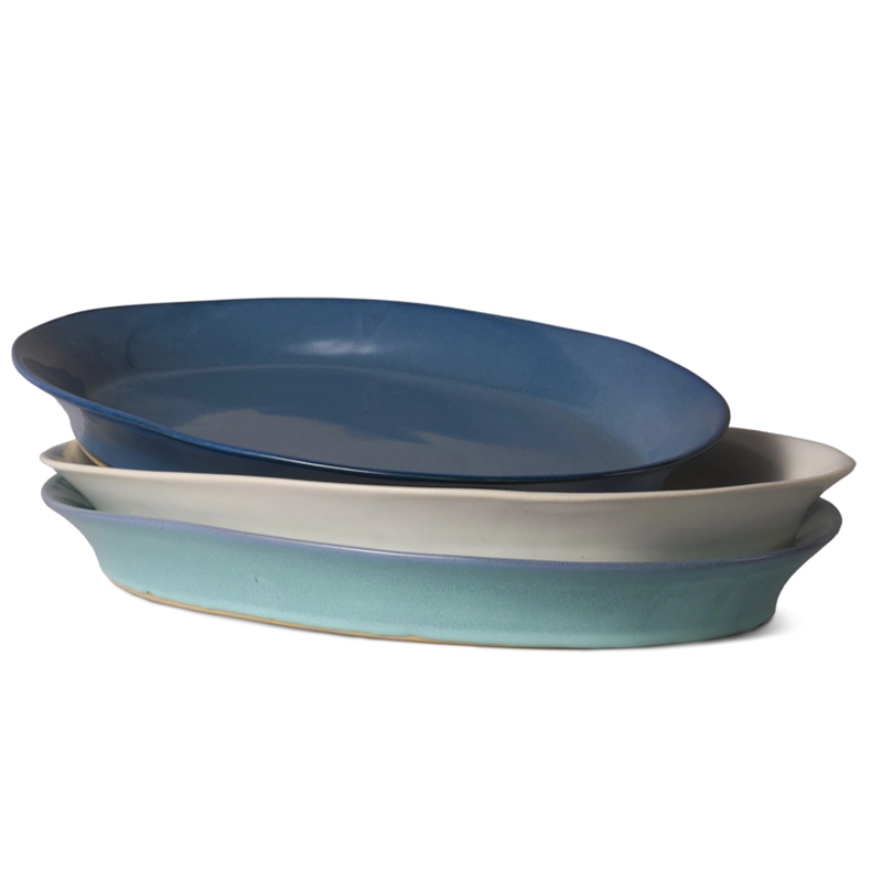 Perfect Hideaways – A stack of three handcrafted ceramic oval platters in varying shades of blue, white, and turquoise, neatly nested together to show their smooth, minimalist design and glazed finish. Perfect Hideaways shop.