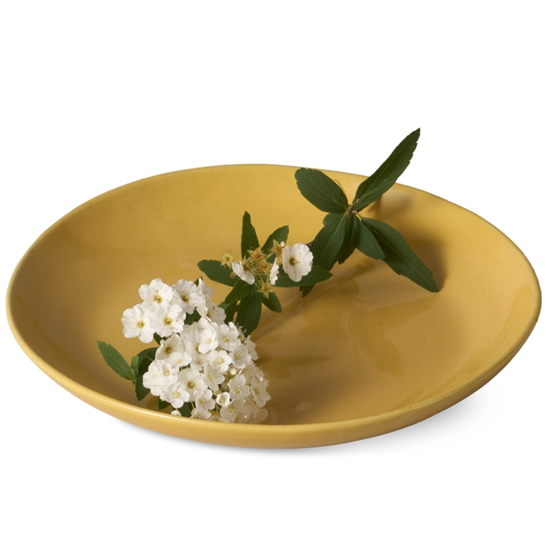 Perfect Hideaways yellow ceramic side plate with a smooth matte finish, featuring a delicate sprig of white flowers and green leaves resting in the center, styled for a natural, minimal aesthetic. Perfect hideaways shop.